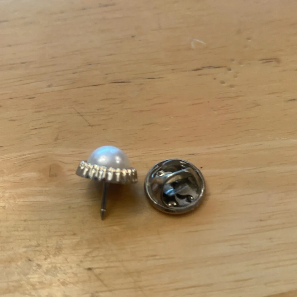 Small faux pearl in gold tone trim brooch. Use on scarf, lapel or tie.